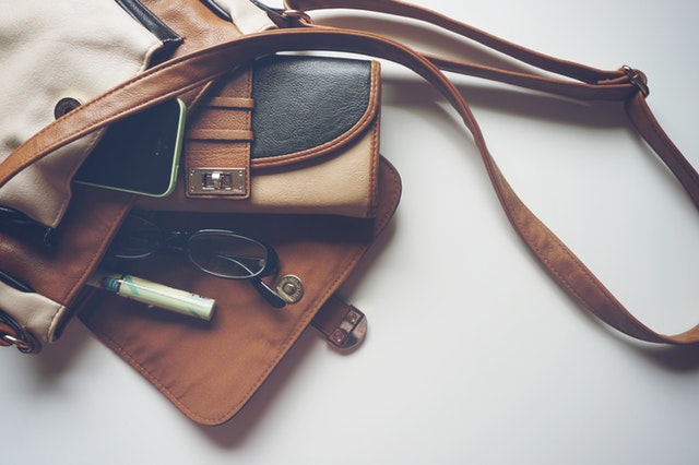 Hnedá kožená taška s peňaženkou a okuliarmi
