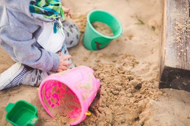 Dieťa sa hrá s formičkami v piesku.jpg